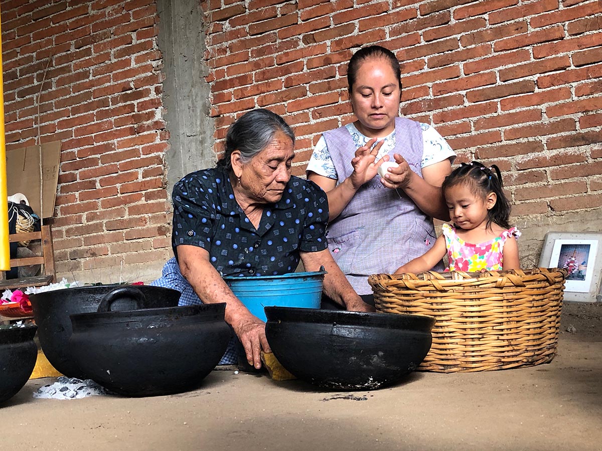 Mother, daughter and grandmother making traditional Oaxacan candles at the Casa de Las Velas in Teotitlan, Oaxaca.